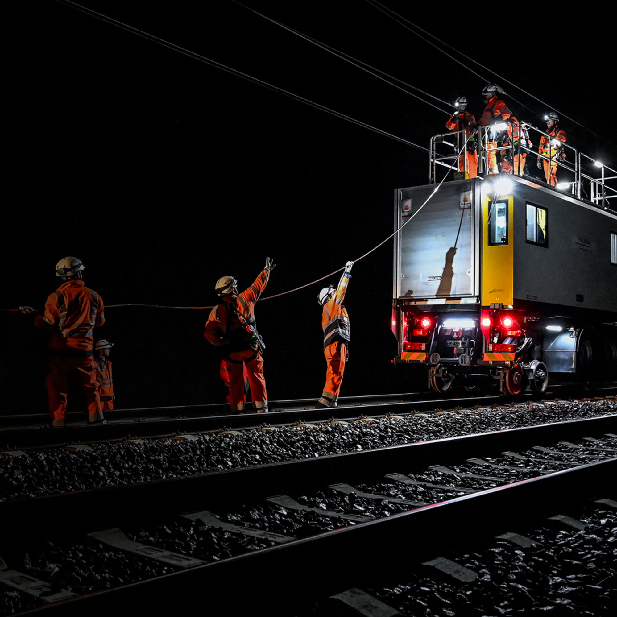 Collaborateurs sur un chantier ferroviaire de nuit